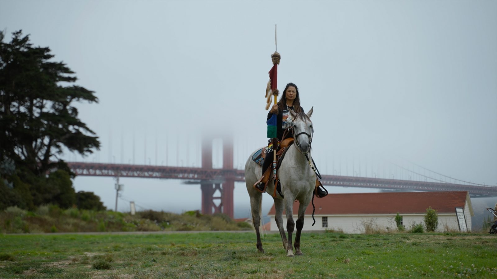 a woman on horseback with the Golden Gate Bridge behind