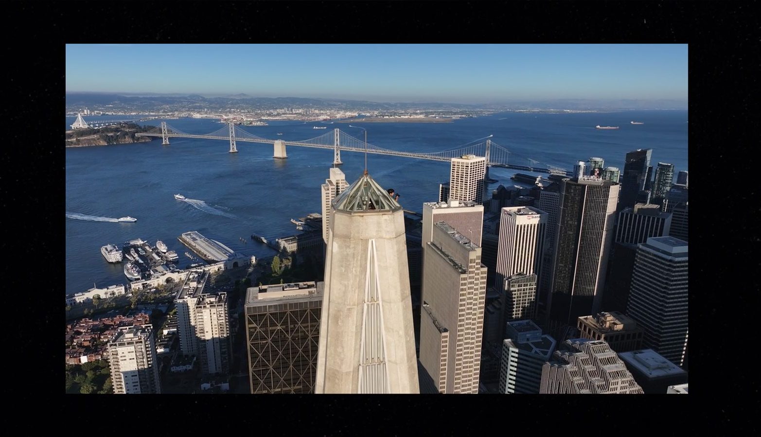 aerial of the Transamerica Pyramid tip with the Bay Bridge beyond