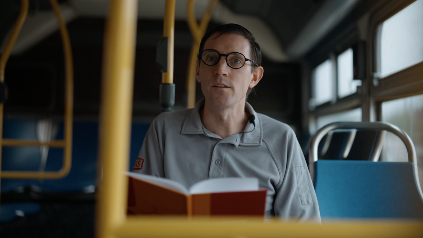 a Muni driver holding a poetry book on a bus